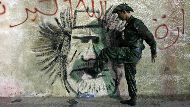 Libyjský voják Přechodné národní rady kope do zdi, na které je hanlivě