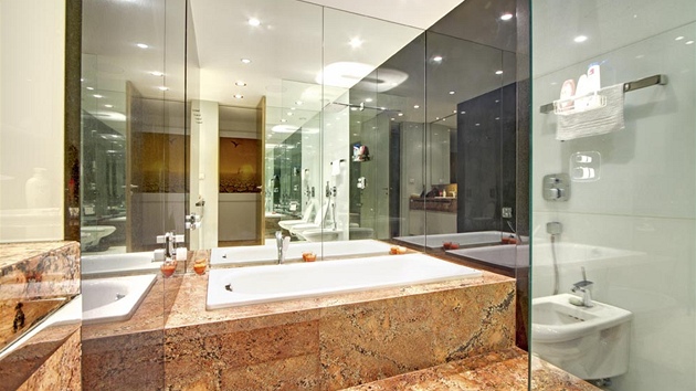 Koupelna je opticky zvětšena zrcadly a z části obložena mramorem. Pro zvýšení