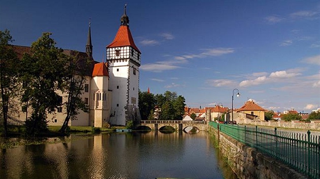 Vodní zámek Blatná se zrcadlí v pilehlém rybníce.