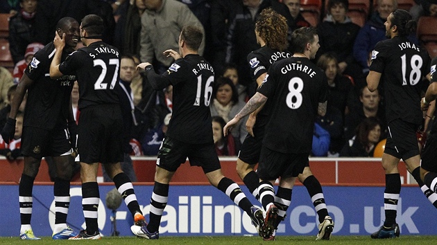 PROCESÍ GRATULANT�. T�i góly vsítil Demba Ba z Newcastlu do branky Stoke City a