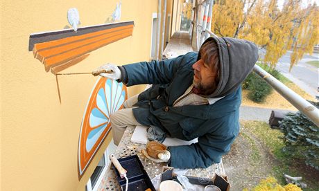 Výtvarník Milo Sláma penáí pvodní malby na novou fasádu.