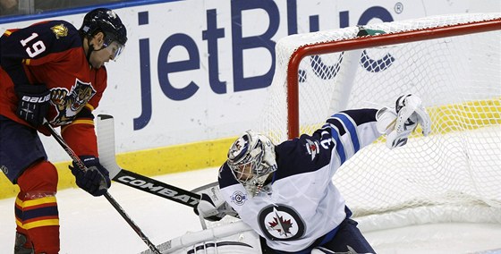 Gólman Ondej Pavelec z Winnipegu likviduje anci Scottieho Upshalla z Floridy.