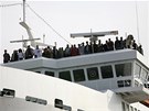 Pasaéi ekají na palub hoící lodi na evakuaci. Poár na trajektu Bella si