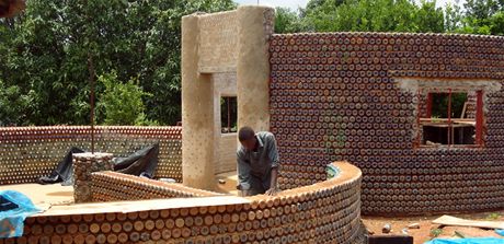Pi stavb domu z PET lahví pomáhal devatenáctiletý Yahaya Musa.