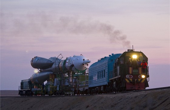 Kosmická loď Sojuz TMA-22 se svým nosičem na cestě na startovací dráhu. Táhne ji lokomotiva TEM2.