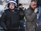 Zranného extremistu odvádí písluník polské policie stranou (11. listopadu