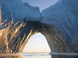 Klonící se slunce bhem polárního dne osvtluje ohromný oblouk z grónského