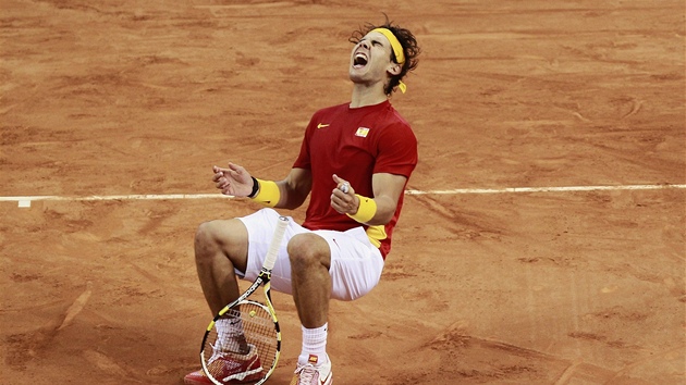 Španělský tenista Rafael Nadal padá k zemi poté, co po dlouhé bitvě porazil ve