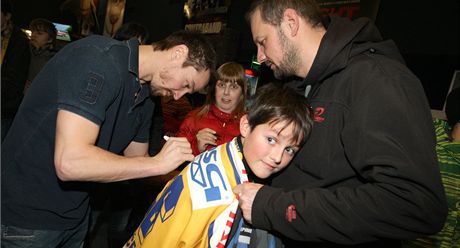 NA PAMÁTKU. Zlínský hokejista Petr ajánek (vlevo) se podepisuje malému...