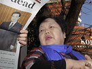 Lidé v Tokiu si tou zprávy o Kim ong-ilov smrti (19. prosince 2011)