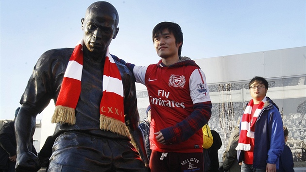 FOTKA SE SOCHOU. Fanouek Arsenalu se nechává vyfotit vedle sochy legendy klubu