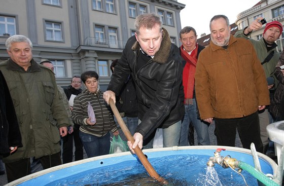 Ministr zemdlství Petr Bendl se snaí vylovit z kád kapra pi návtv v