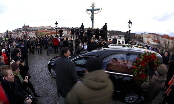 Auto s ostatky Václava Havla projídí Karlovým mostem, v pozadí cíl smuteního...