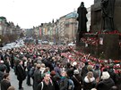 Lidé drí minutu ticha u sochy na Václavském námstí v Praze. (23. prosince