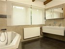 Koupelna má moderní velkoformátovou dlabu a obklad napohled k nerozeznání od