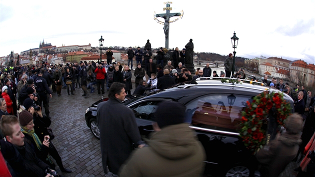 Auto s ostatky Václava Havla projídí Karlovým mostem, v pozadí cíl smuteního...