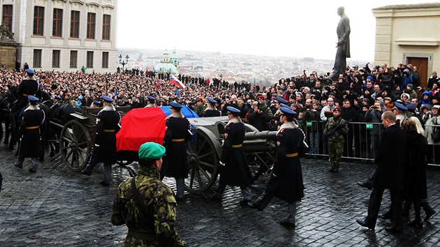 Lafeta s ostatky bývalého prezidenta projídí kolem sochy Tomáe G. Masaryka.