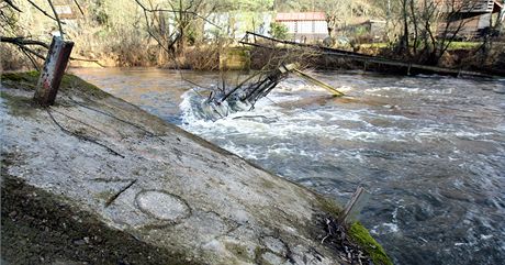 Trosky lávky pes eku Mi u hradu Buben, kterou strhla v lednu 2011 velká voda.