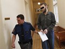 Policista pivádí Martina K. k Mstskému soudu v Praze (5. ledna 2012)
