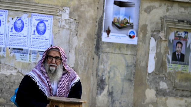 Egypan odpoívá ped volební místností obklopen pedvolebními plakáty bhem