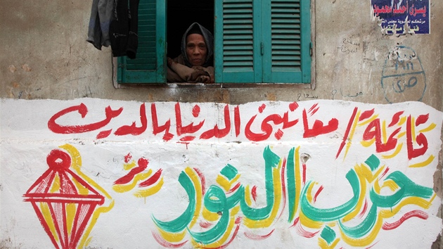 Egypanka hledí z okna nad volebním graffiti islamistické strany Núr, které