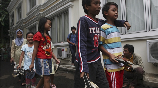 Indonéské dti nesou staré páry letní obuvi na policejní stanici (3. ledna 2012)