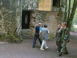 Turisté procházejí kolem trosek Vlího doupte u polského msta Gierlo.