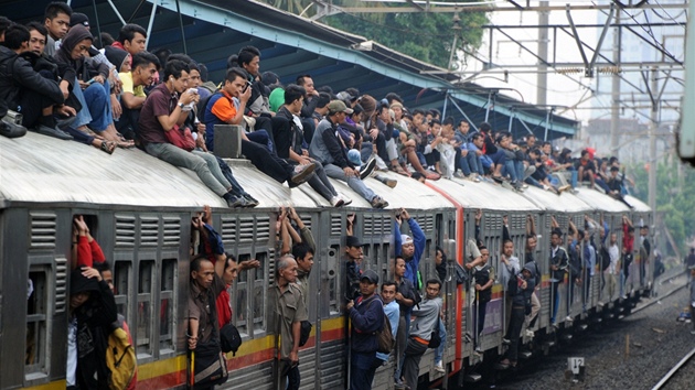 Takhle vypadá klasický indonéský vlak, desítky lidí sedí na střeše, další visí na schůdkách a dveřích.