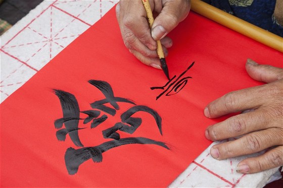 Umělec tvoří kaligrafii v hanojském Chrámu literatury