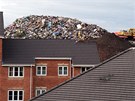 Obí hromady odpadu vykukují nad stechami bytových dom.