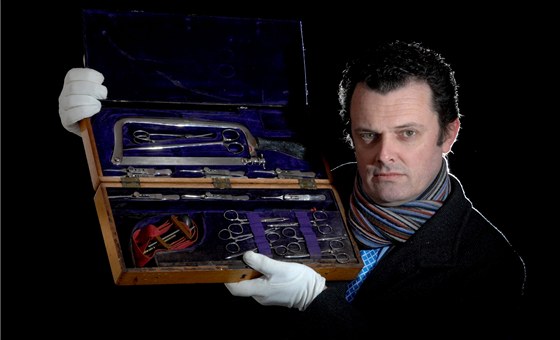 Zamstnanec aukního domu drí v rukou sadu chirurgických nástroj Antona