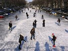 Lidé bruslí na zamrzlém kanálu v nizozemském Amsterdamu. (7. února 2012)