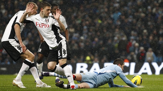 PENALTA! Adam Johnson z Manchesteru City (na zemi) pad po zkroku Chrise Bairda z Fulhamu.
