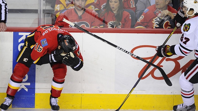 DO OKA TO BOL. Michael Frolk (vpravo - Chicago) fauluje vysokou hokejkou Toma Kostopoulose z Calgary. Pi jeho nslednm vylouen padl rozhodujc gol zpasu.

