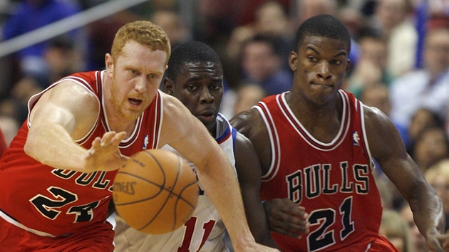 Brian Scalabrine (vlevo) a Jimmy Butler z Chicaga bojují o mí s Jrue Holidayem