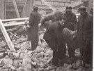 Vyproovaní mrtvých a zranných z náletem pokozených a zniených dom na