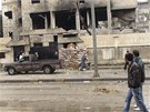 Syané se dívají ve mst Homs na budovu pokozenou boji mezi povstalci a