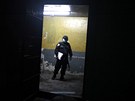 Honduraský policista v masce se dívá do jedné z místností vznice Comayagua.
