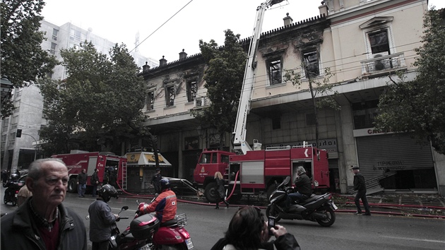 Obyvatelé Atén obhlíí následky noních stet. (13. února 2012)