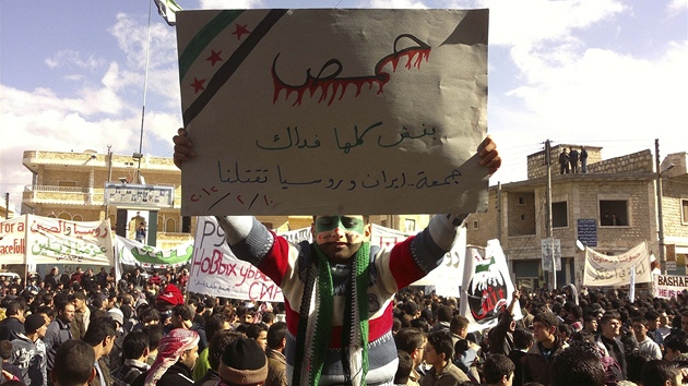 Protesty v syrskmmst Bin nedaleko Idlibu. Na plaktu stoj: "Jsme s Homsem. Rusko a rn ns zabj" (10. nora 2012)