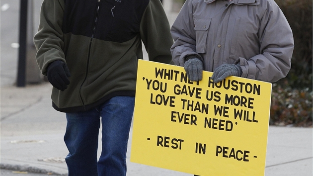 Fanoušci se ke kostelu nedostanou, přesto se přišli rozloučit. Tato žena nese ceduli se vzkazem "Dala jsi nám víc lásky, než kdy budeme potřebovat. Odpočívej v pokoji" (Newark, 18. února 2012).