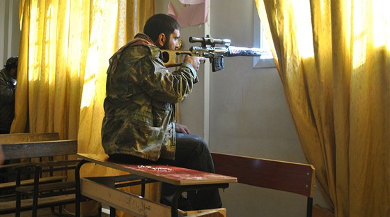 Syrský rebel s odstelovaskou pukou íhá v Homsu na vládní jednotky. (28.
