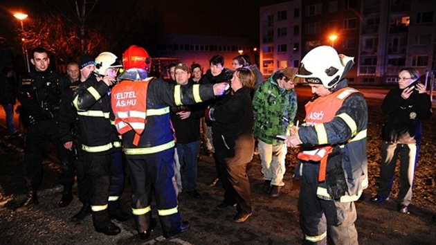 Hasiči při evakuaci lidí z domu v Praze 9