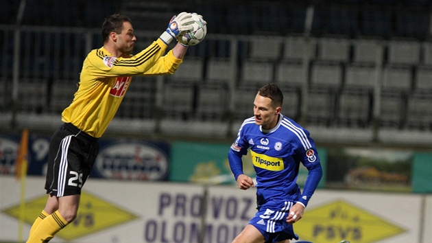 P�I�EL POZD�. Bud�jovický branká� Michal Dan�k chytá mí� p�ed dobíhajícím