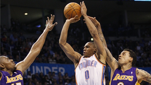 Russell Westbrook z Oklahoma City Thunder stílí pes Andrewa Bynuma (vlevo) a