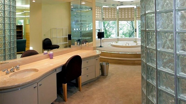 Luxusní koupelna má stny z luxfer a velkou víivku.