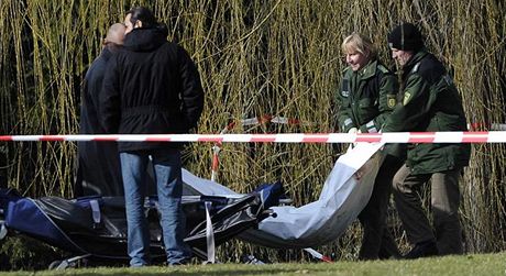 Policisté odnáejí tlo zabitého lovka poblí koly Albertville, kde zabíjel