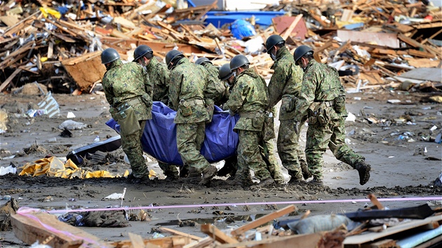 Japont vojci nesou tlo jedn z obt plivov vlny tsunami ve mst Minamisanriku. (18. bezna 2011)