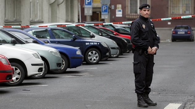 Policista hlídá, aby nikdo nevnikl pes pásku do budovy Krajského soudu v