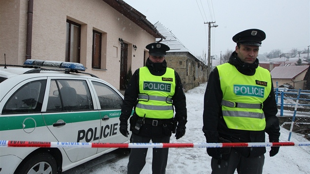 Policist hldkuj u domu v Doubravch na Zlnsku, kde nali tajn sklad zbran. (8. bezna 2012)